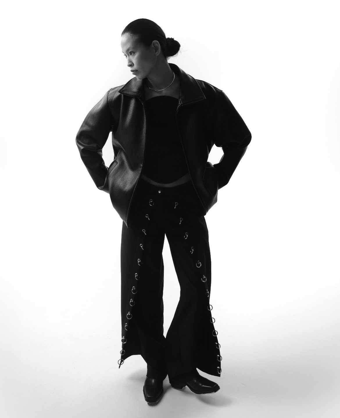Silhouette en pied, veste en cuir et pantalon à anneaux